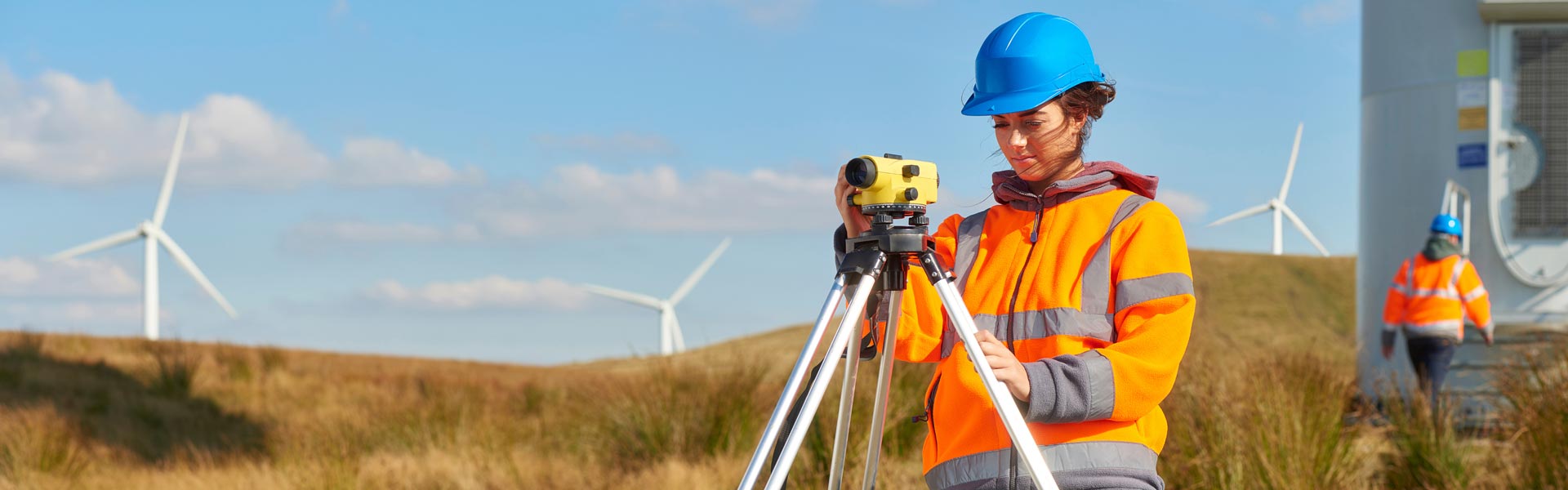 Woman in a hard had with windmills in the background