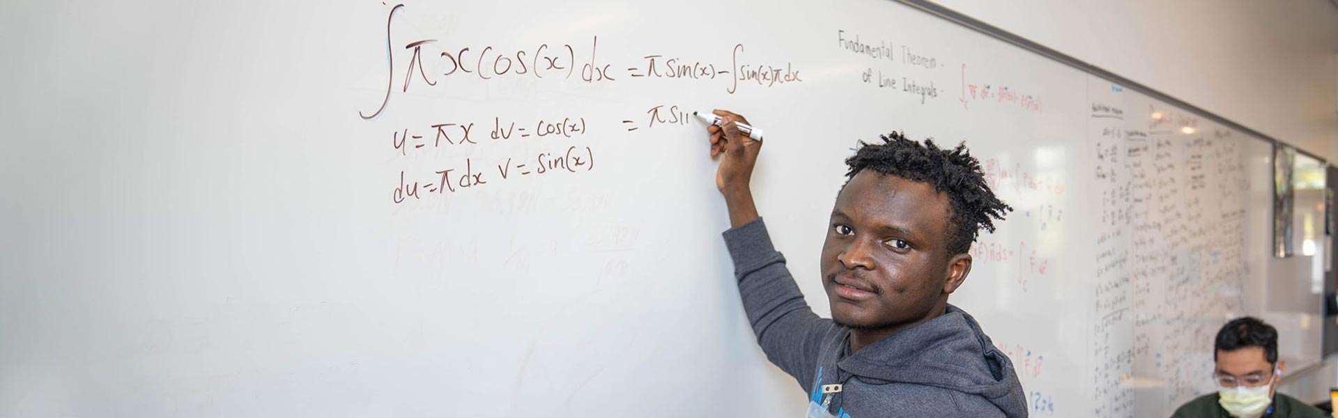 Student writing a math equation