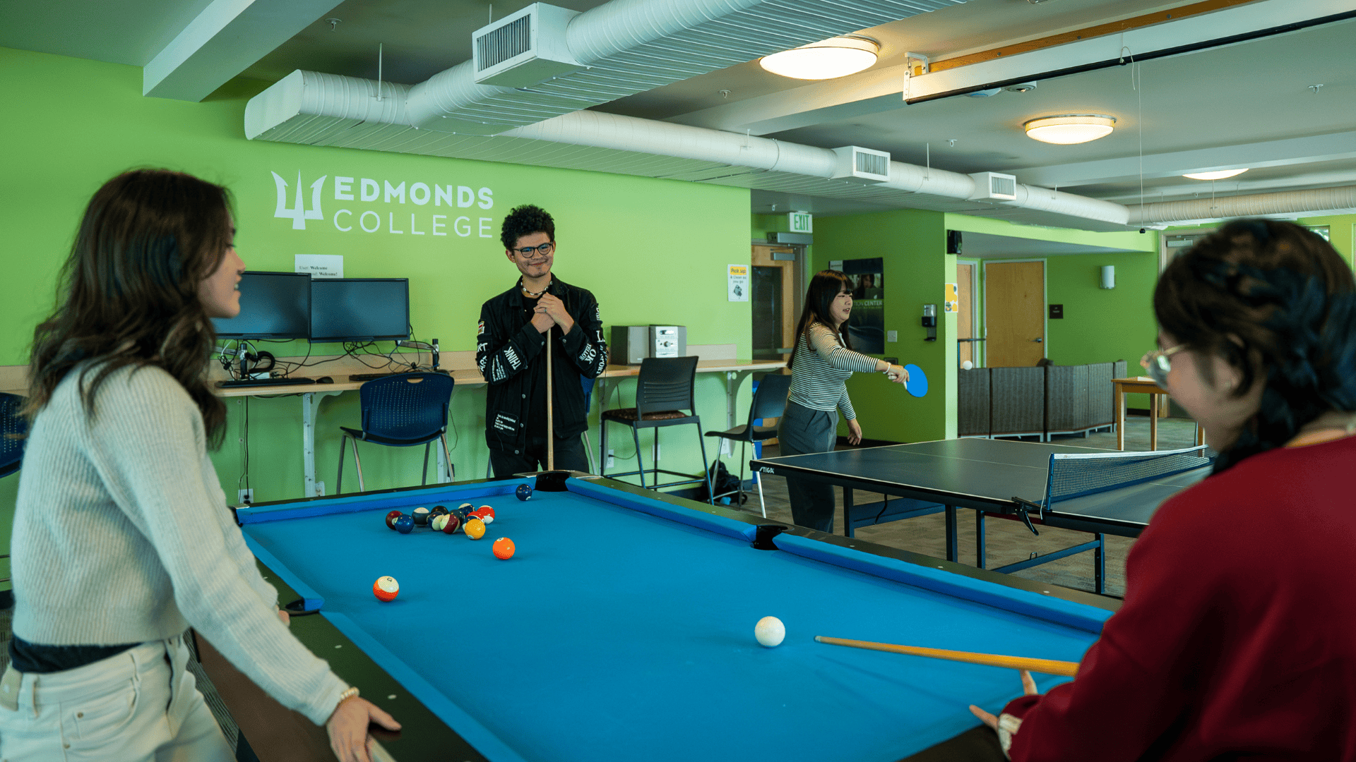 students playing pool in the community room